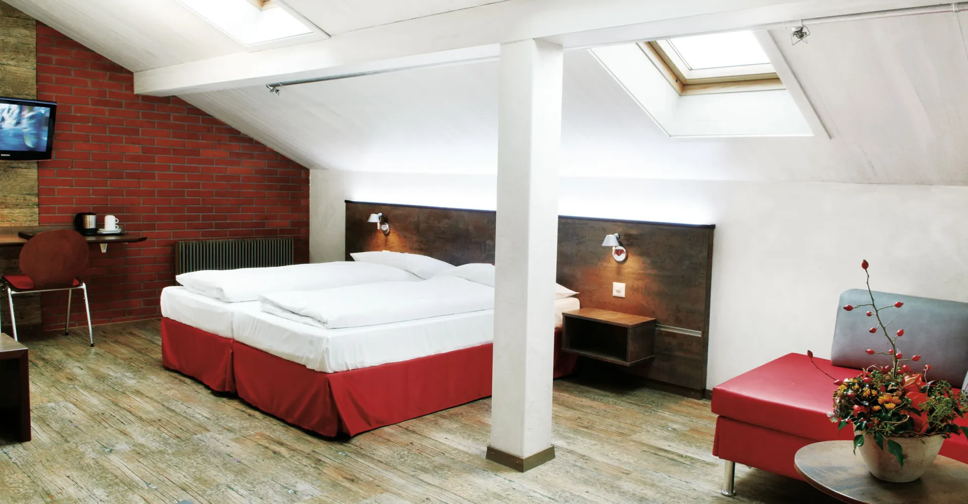 Sorell Hotel Arabelle Triple room with seating area and desk