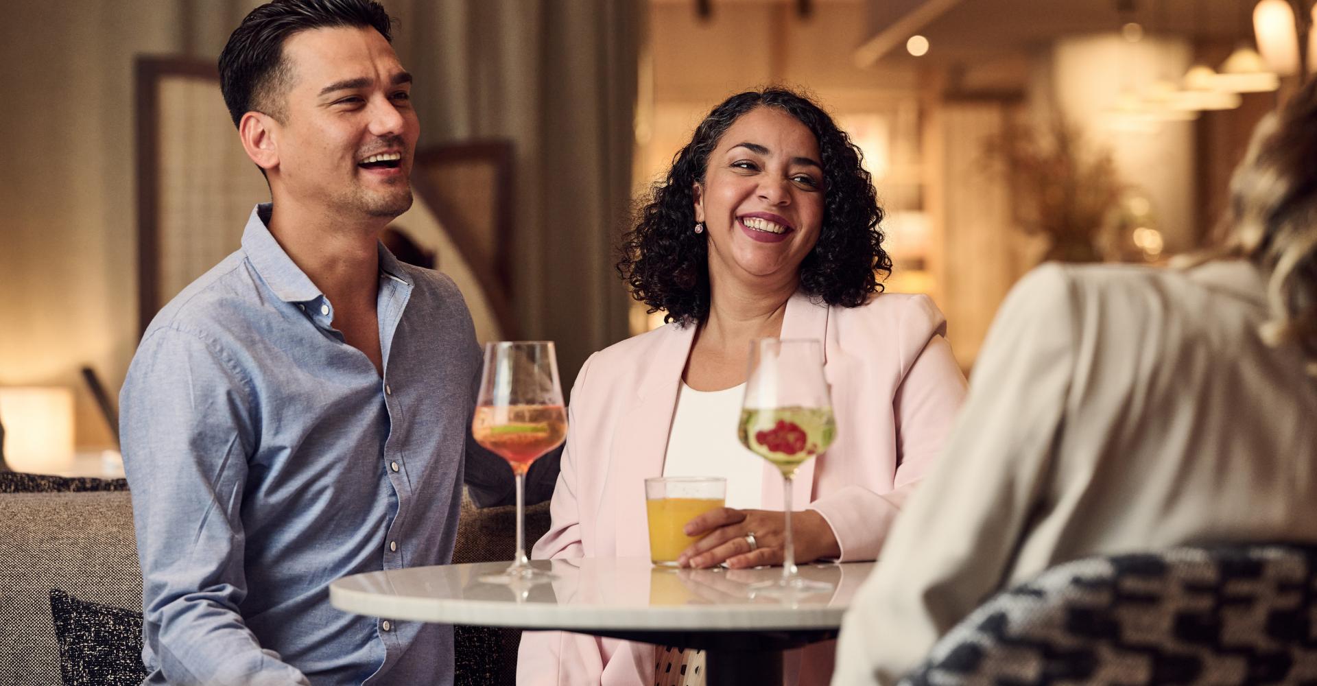 Paar sitzt an einem Tisch und trinkt