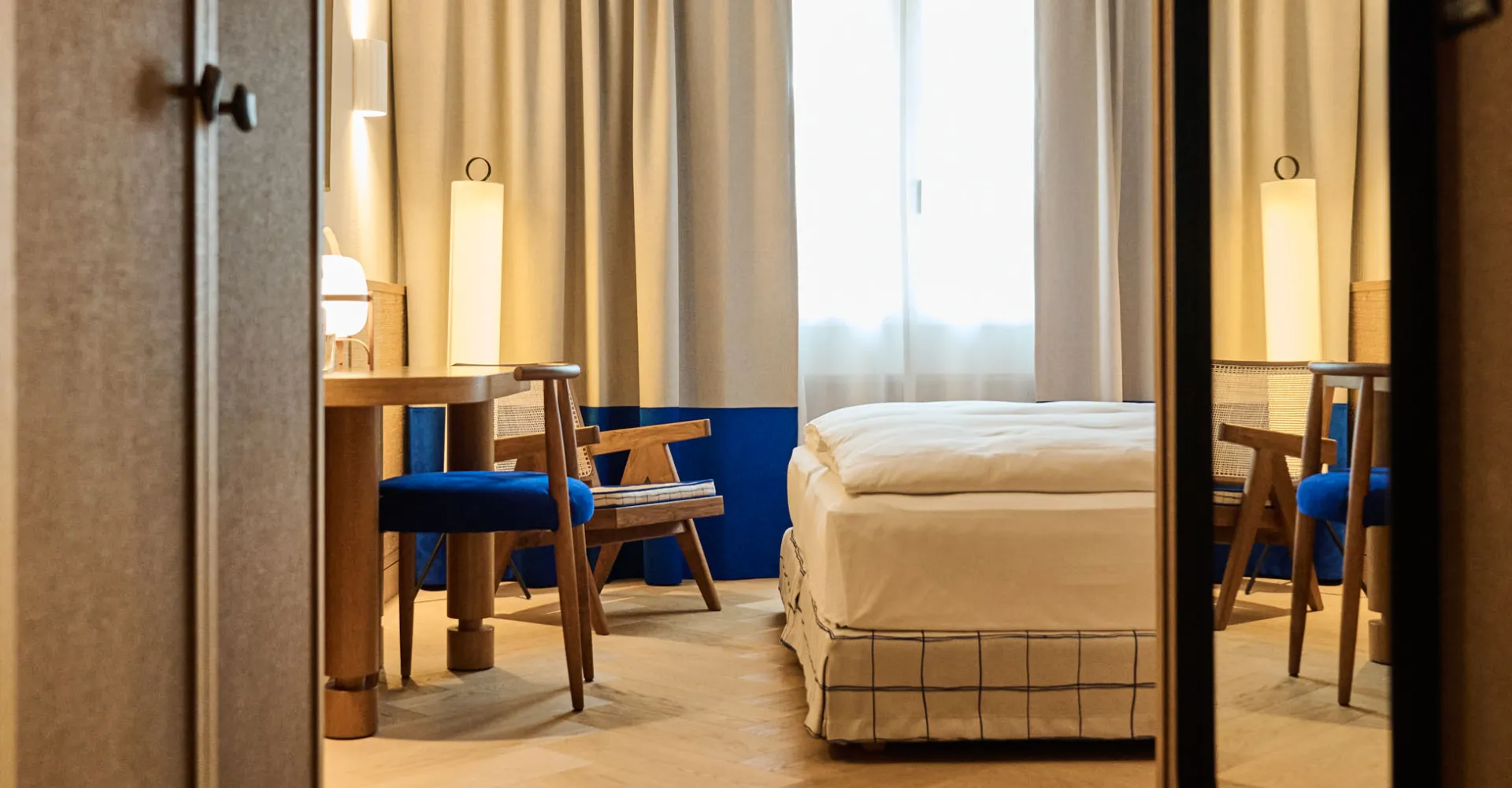 Hotel room entrance with a view of the bed