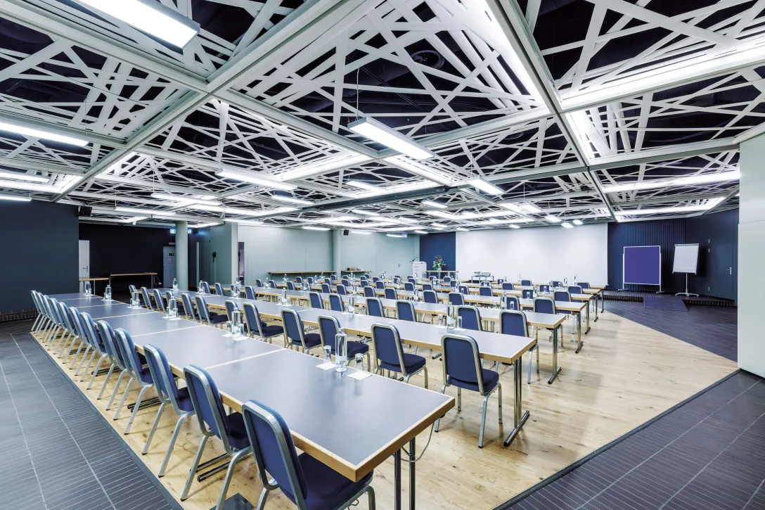 Seminarraum mit Tischen und Stühlen in einer Reihe