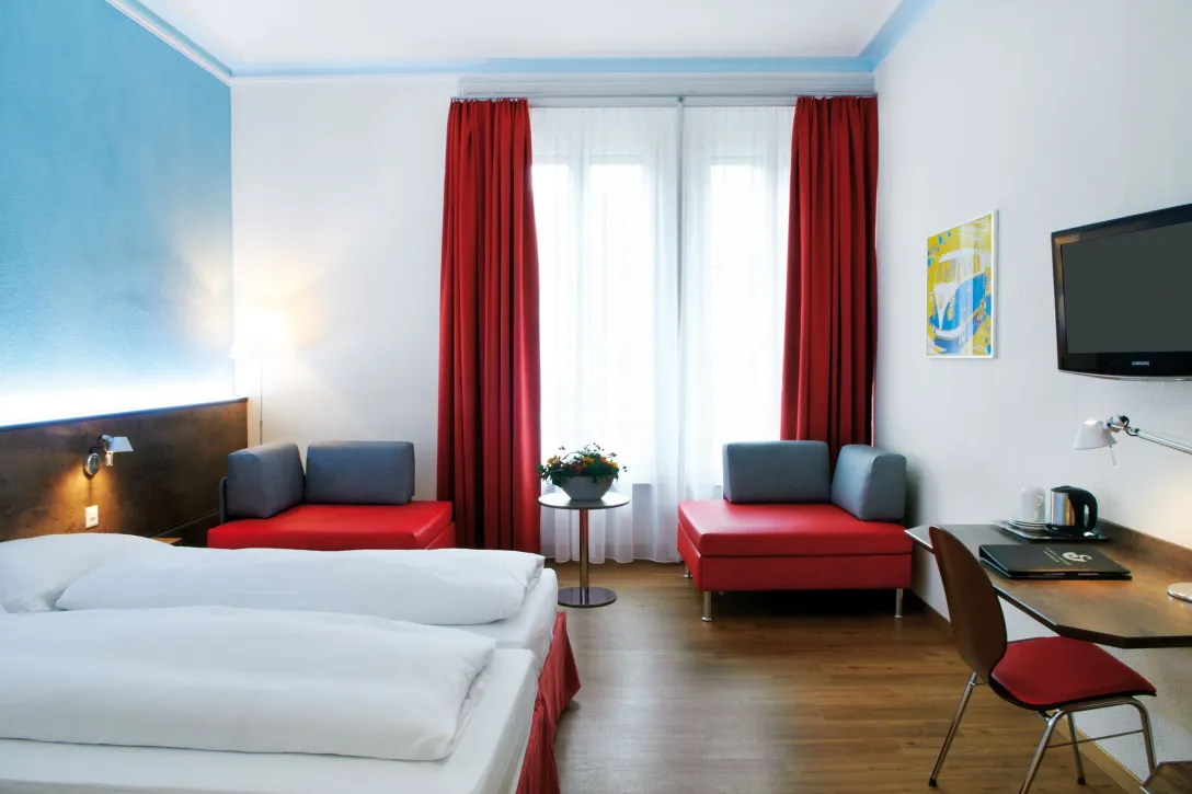 Sorell Hotel Arabelle Twin room with seating area and desk