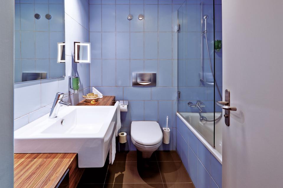 Sorell Hotel Ador Standard Dreibettzimmer Badezimmer mit Badewanne und Dusche