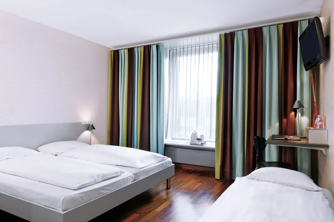 Sorell Hotel Ador Standard Dreibettzimmer mit Schreibtisch