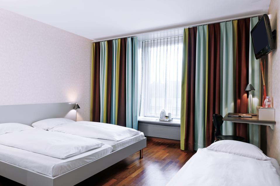 Sorell Hotel Ador Standard Dreibettzimmer mit Schreibtisch
