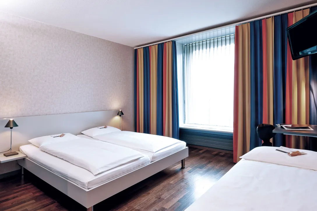 Sorell Hotel Ador Standard Dreibettzimmer mit Schreibtisch