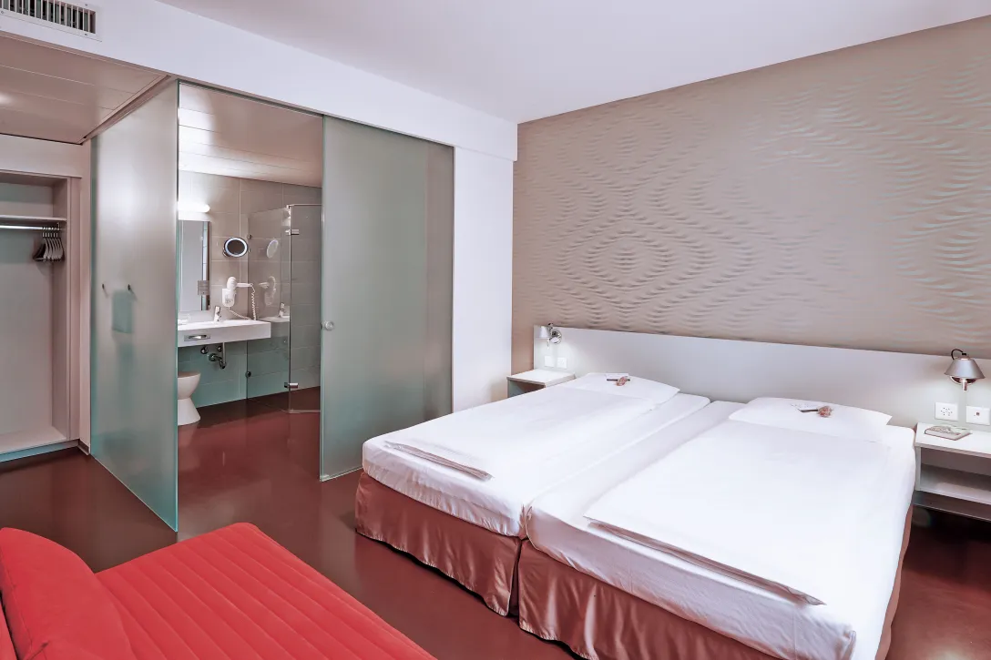 Sorell Hotel Ador Business Dreibettzimmer mit Sitzecke