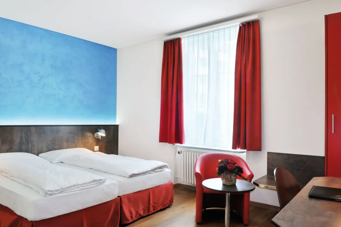 Sorell Hotel Arabelle Twin room with seating area and desk