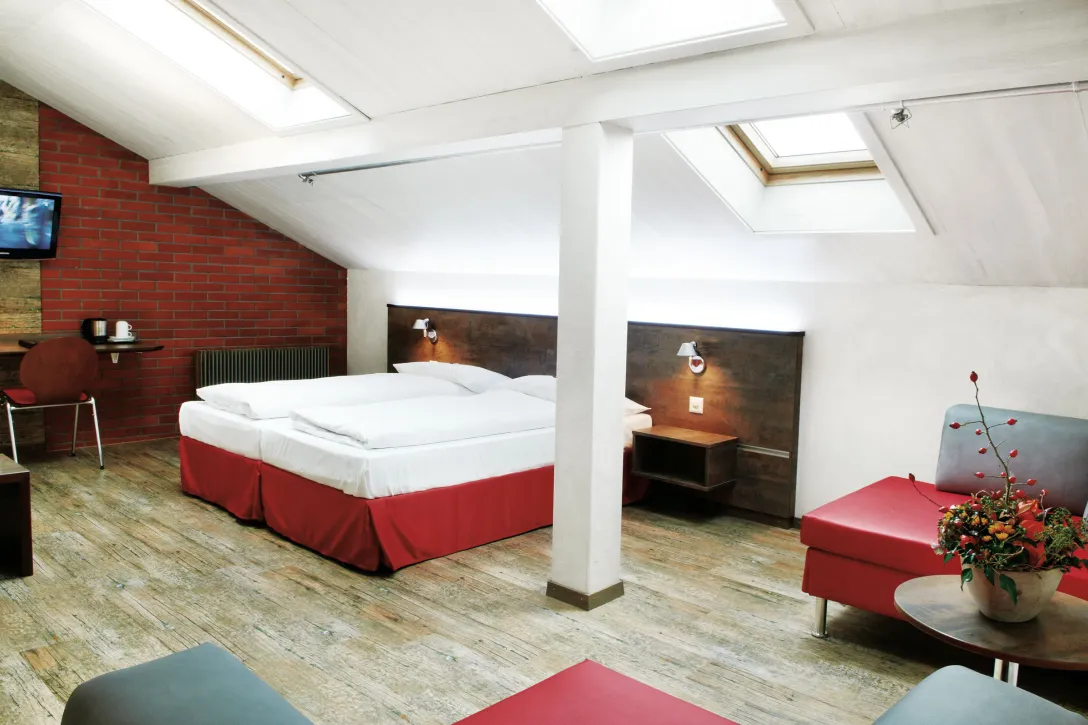 Sorell Hotel Arabelle Triple room with seating area and desk