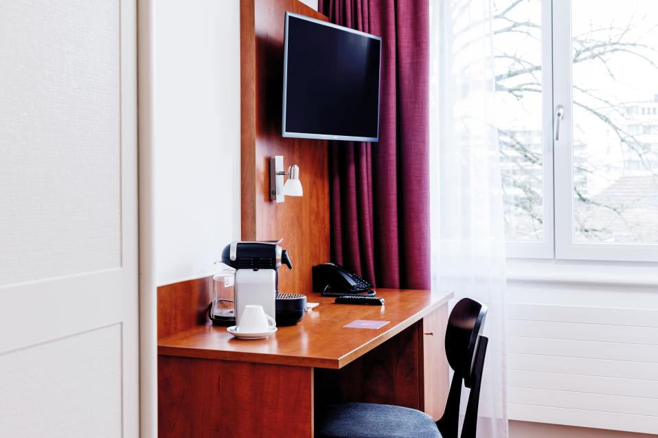 Sorell Hotel Sonnental Standard Einzelzimmer mit Schreibtisch und Fernseher