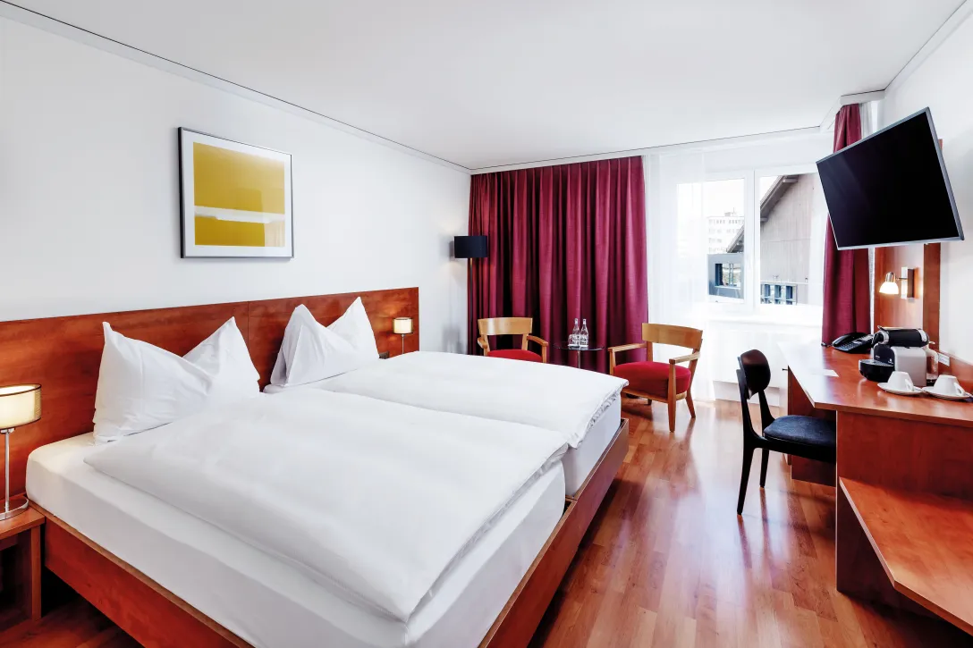 Sorell Hotel Sonnental Superior Twin room with desk and seating area