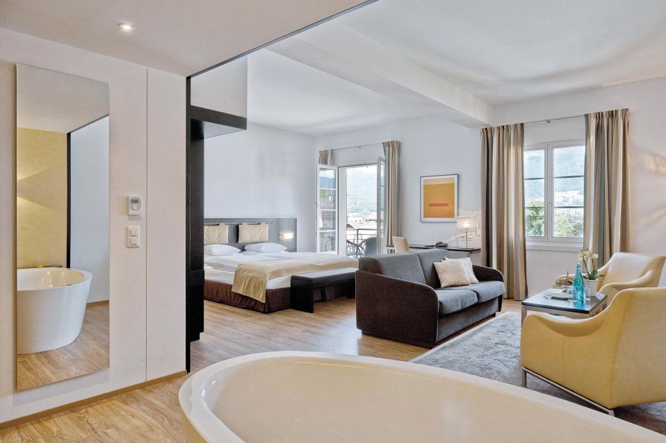 Junior Suite mit Wohnzimmer und Badewanne im Sorell Hotel Tamina in Bad Ragaz