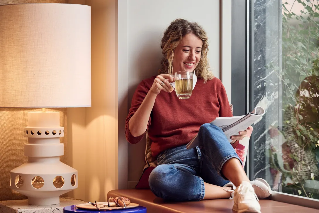 Woman sitting at the window drinking tea