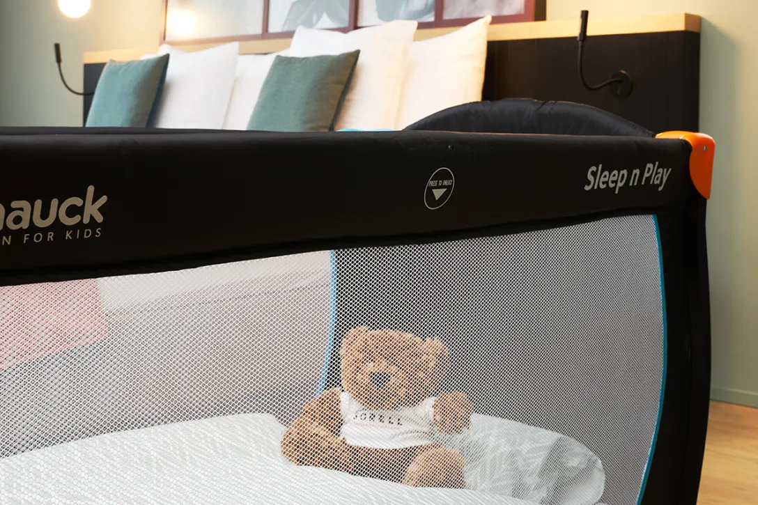 Babybett mit Teddybär im Bett