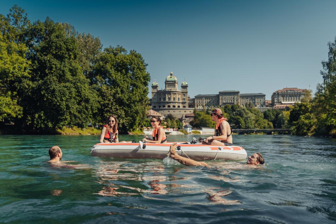 Menschen auf der Aare vor dem Bundeshaus auf Gummibooten