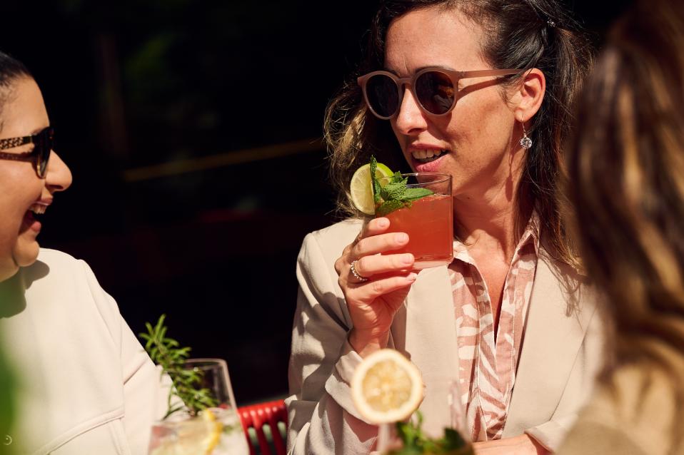 Frau trinke Cocktail auf der Terrasse in der Sonne
