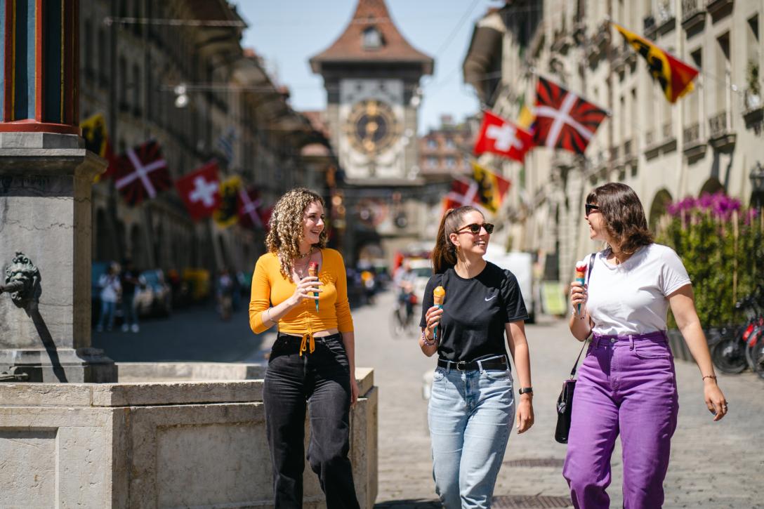 drei Frauen laufen durch die Stadt Bern und essen Glace
