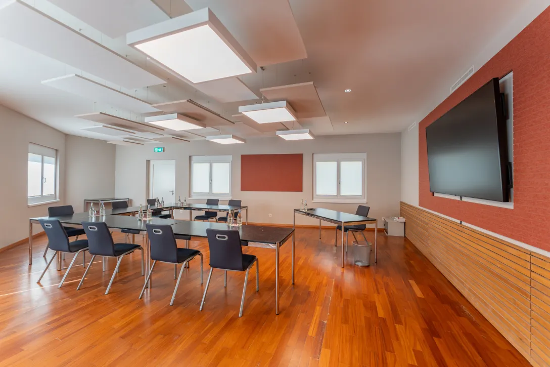Meetingraum mit U Form Stuhlung und Fernseher an der Wand