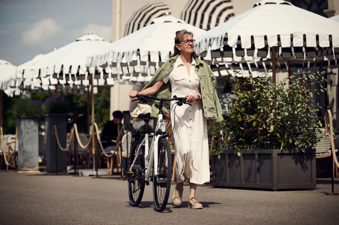 Woman pushes bicycle on the promenade in Rapperswil