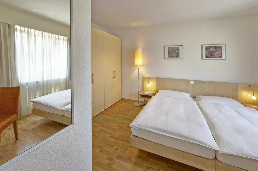 Zwei Bett Zimmer mit Schrank und Spiegel