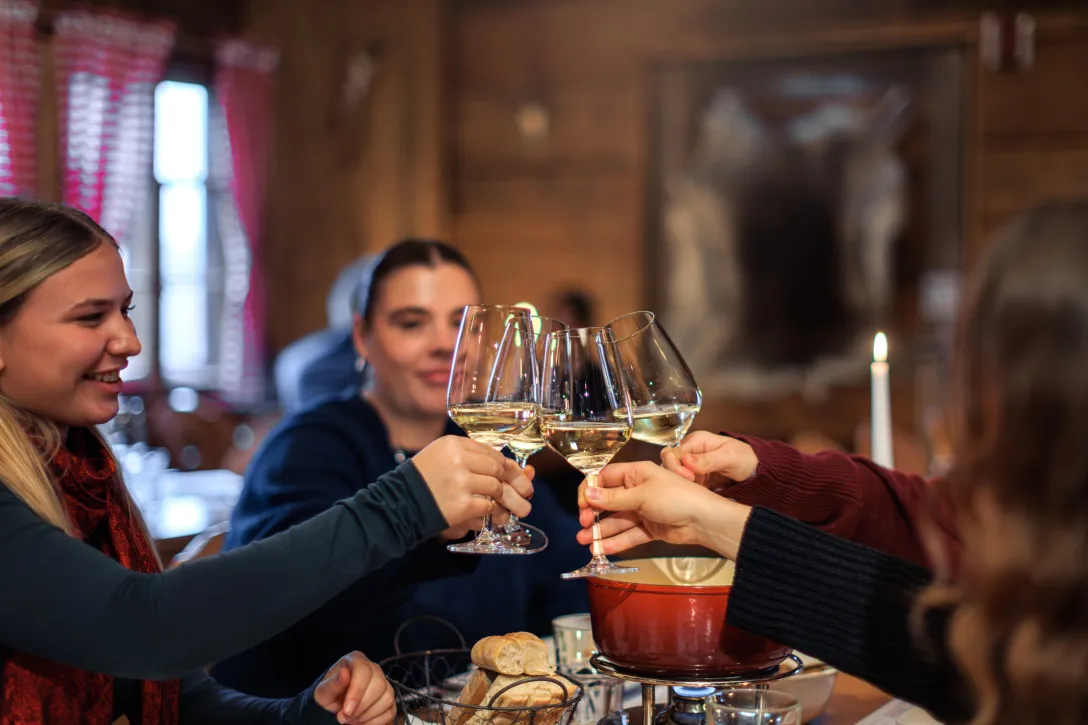 vier Freundinnen stossen gemeinsam mit Weisswein an