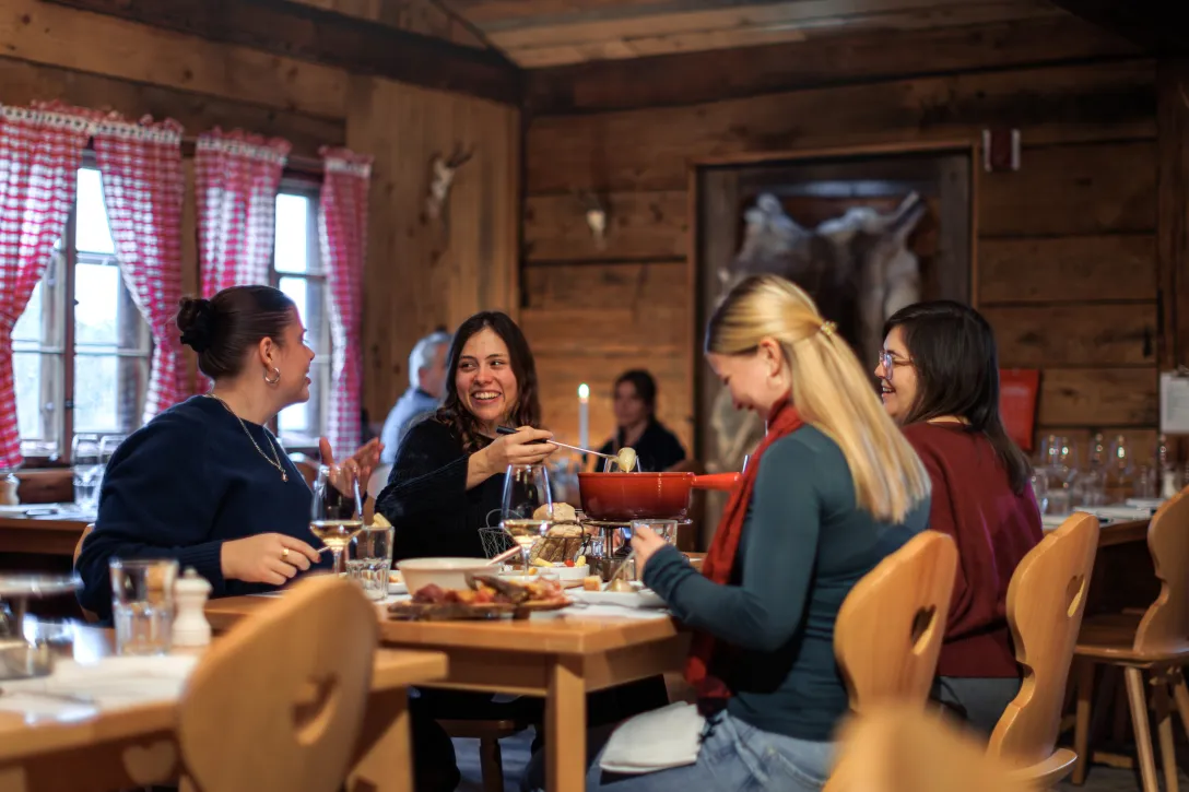 Vier Freundinnen essen gemeinsam Fondue
