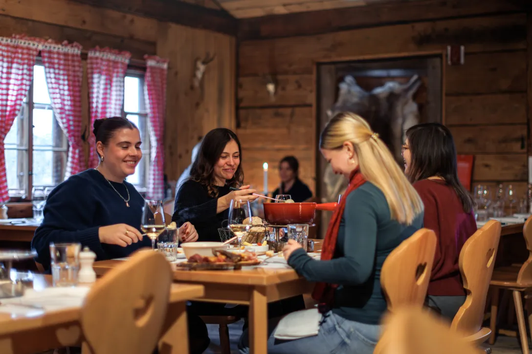 Vier Freundinnen essen gemeinsam Fondue
