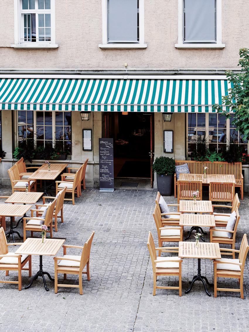 Terrasse mit Tischen und Stühlen vor dem Hotel Krone