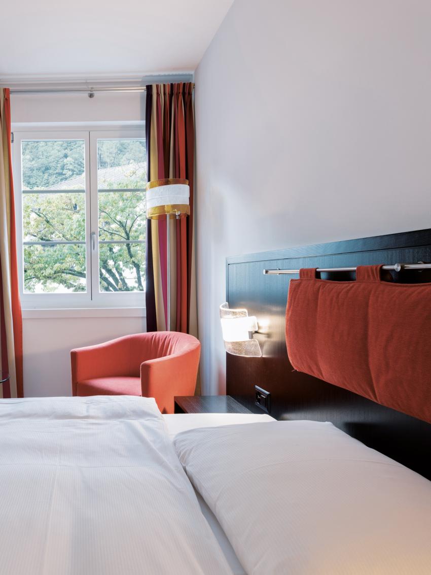 Aufnahme eines Zimmers im Hotel Tamina mit Bett und Schreibtisch