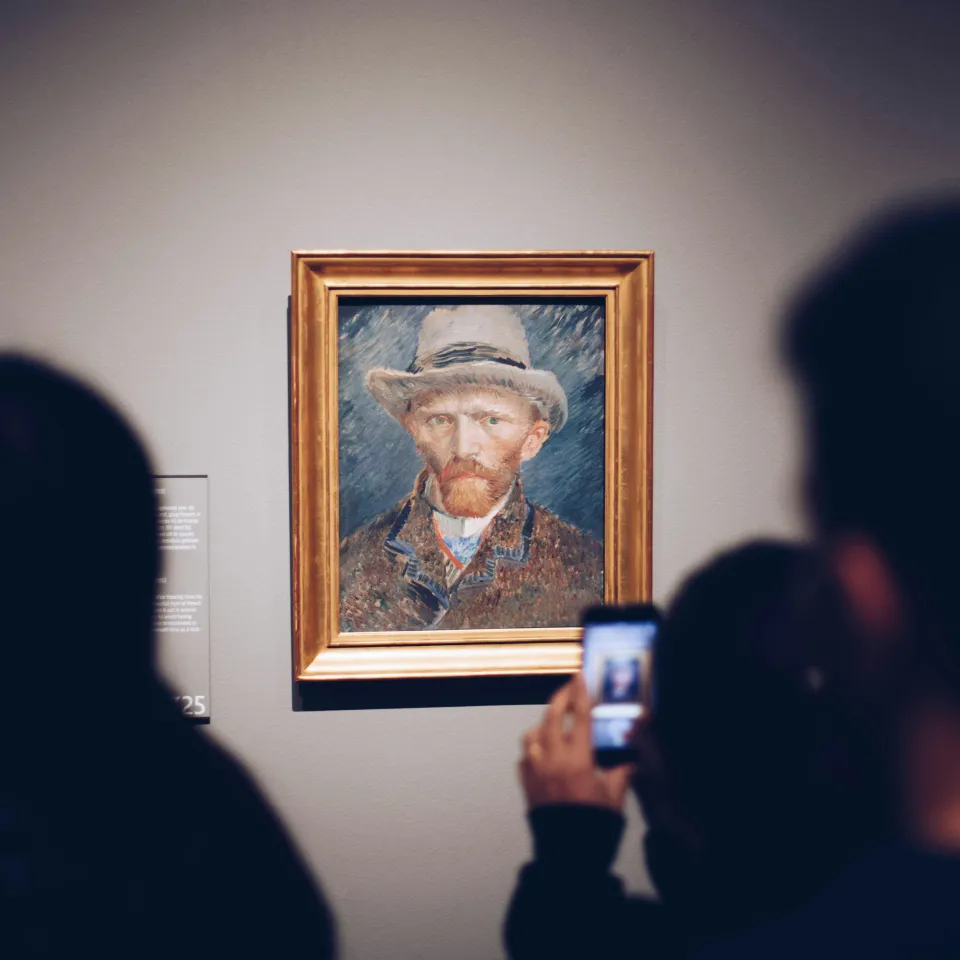 Person takes a picture of a painting
