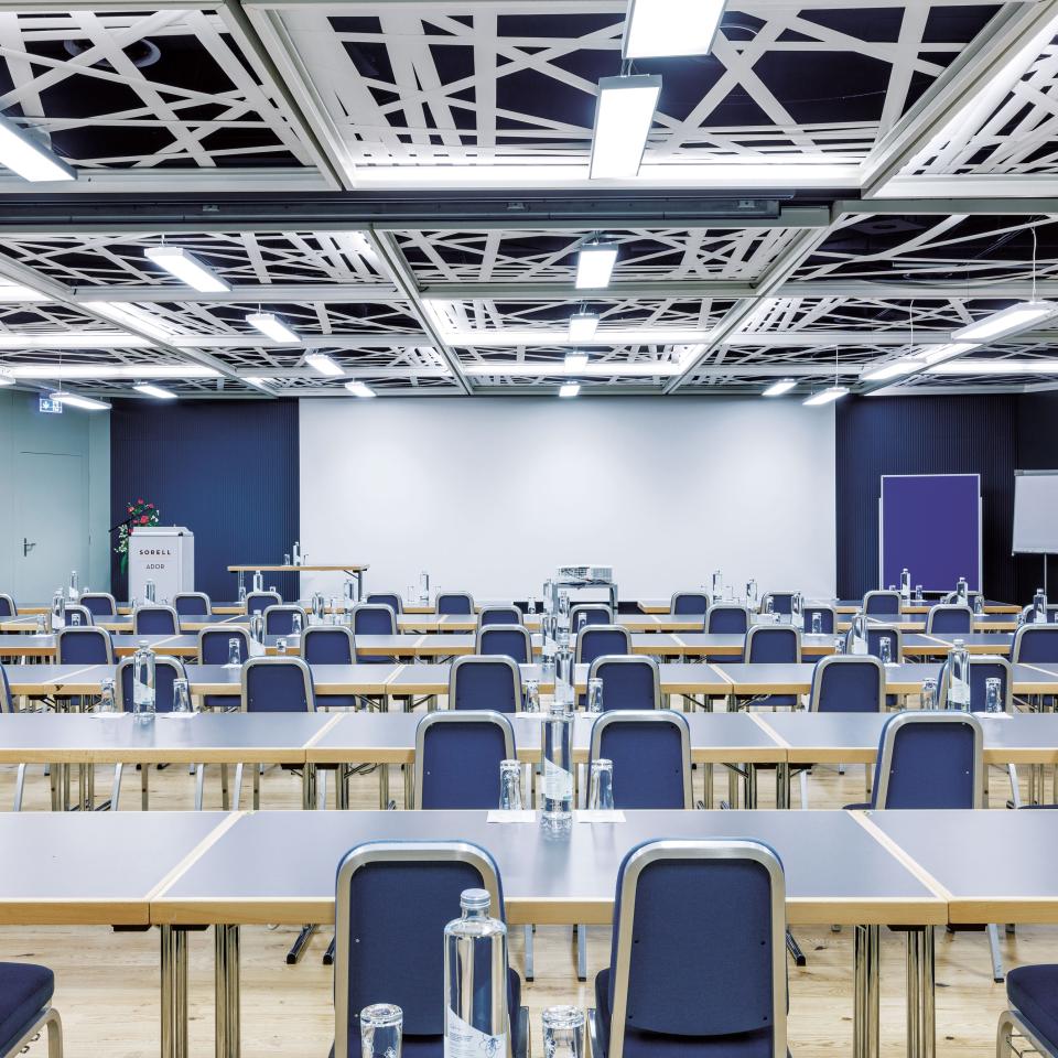 Seminarraum mit Tischen und Stühlen in einer Reihe