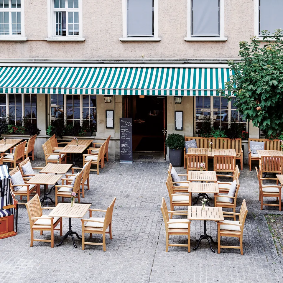 Terrasse mit Tischen und Stühlen vor dem Hotel Krone