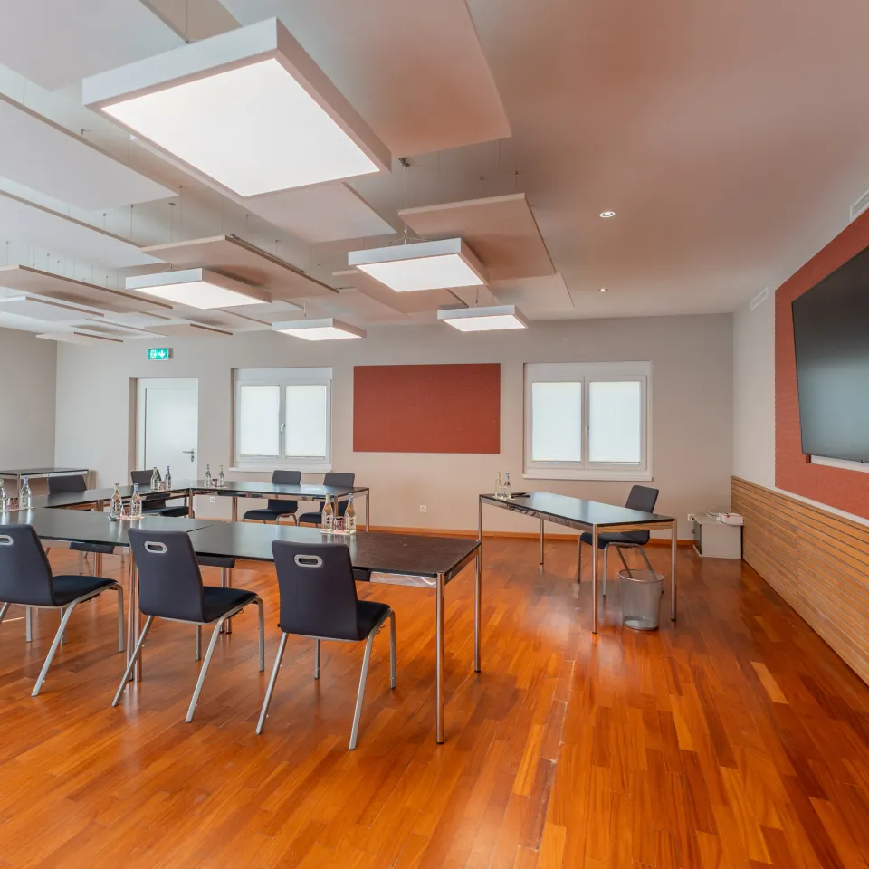 Meetingraum mit U Form Stuhlung und Fernseher an der Wand