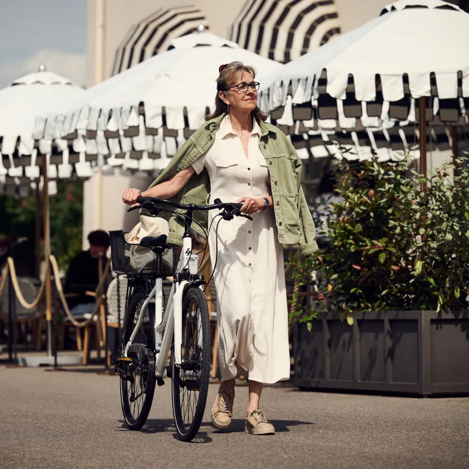 Woman pushes bicycle on the promenade in Rapperswil