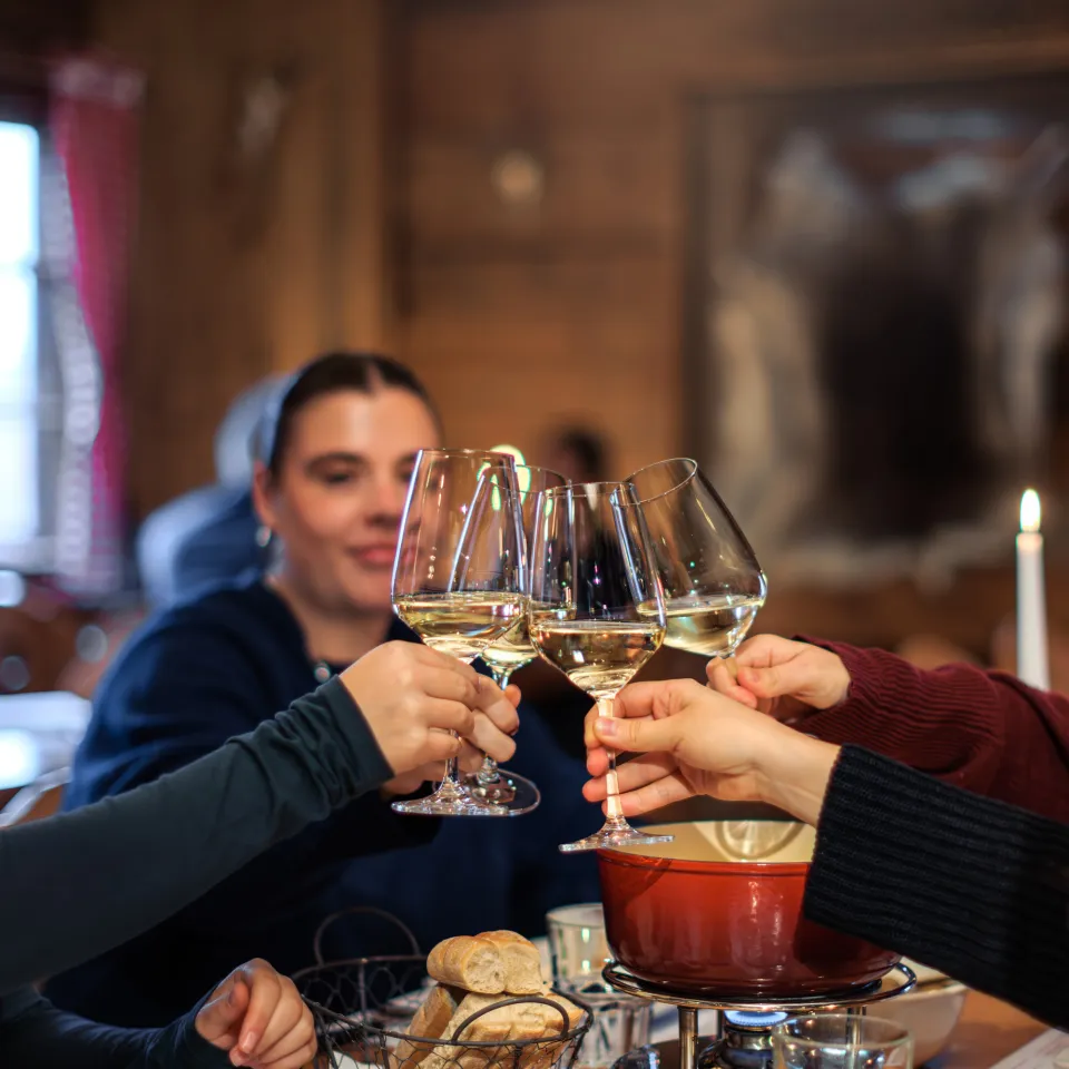 Four girlfriends toasting together with white wine