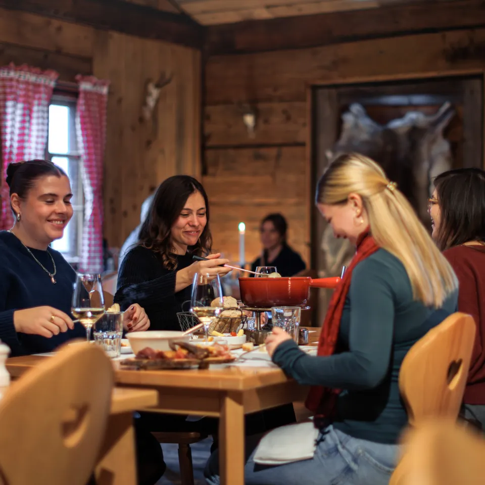 Vier Freundinnen essen gemeinsam Fondue