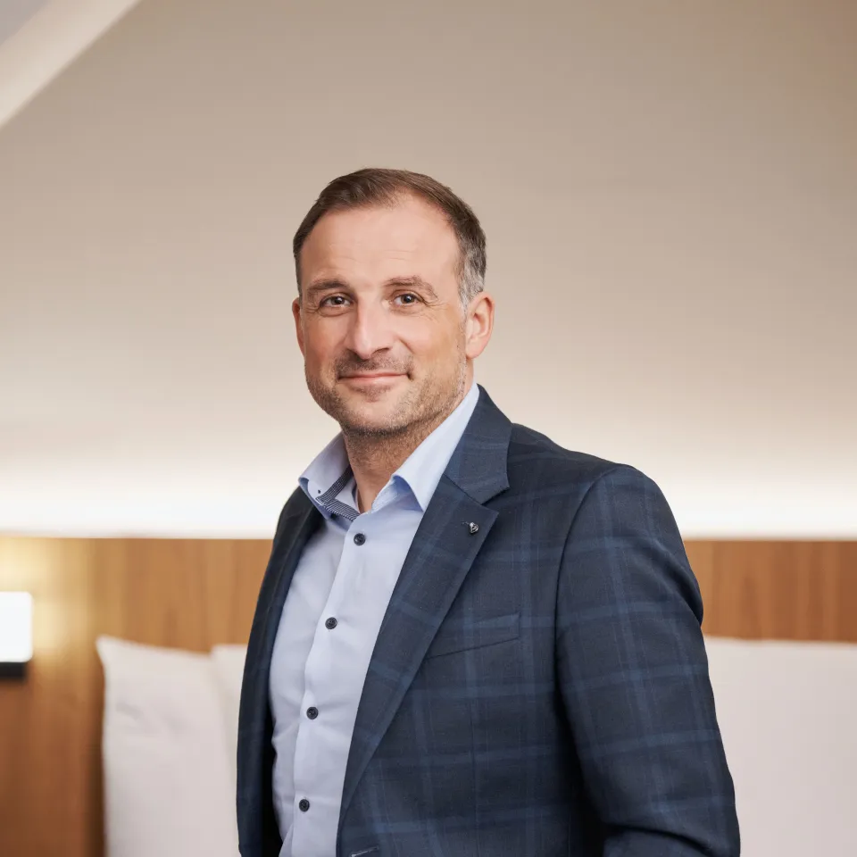 A man in a suit in a hotel room.