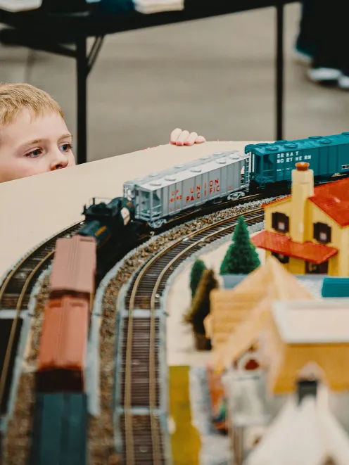 little boy marvels at the model railroad