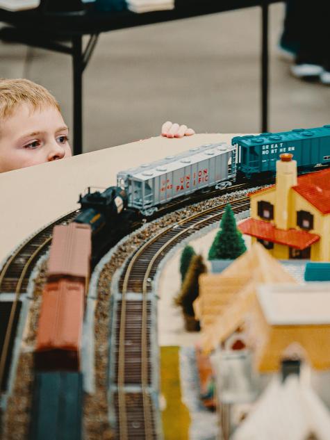 kleiner Junge bestaunt die Modeleisenbahn