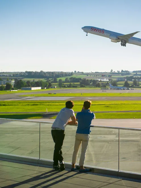 Personen beobachten Flugzeuge beim Starten am Flughafen Zürich