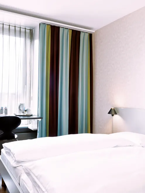 Bett und Schreibtisch im Standard Zimmer im Ador