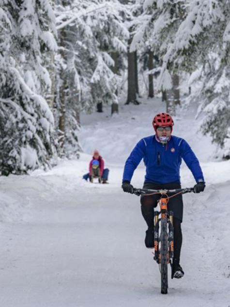 Mann fährt Velo im Schnee