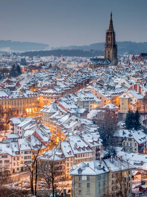 Bern with snow-covered roofs at dusk