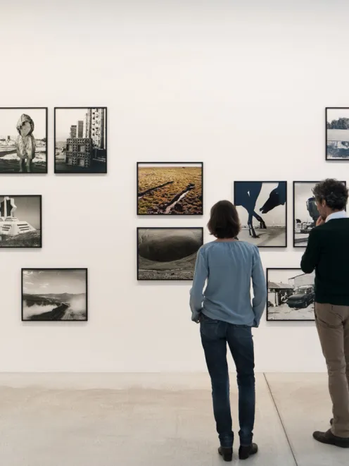 People looking at photographs in a museum
