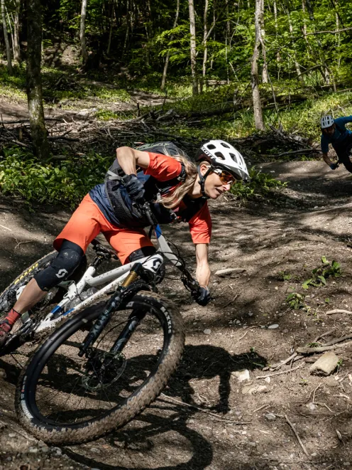 Frau auf Mountainbike fährt Berg hinunter