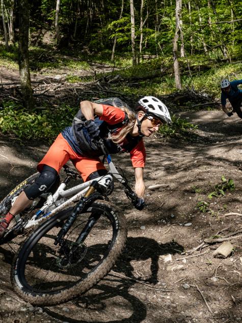 Frau auf Mountainbike fährt Berg hinunter