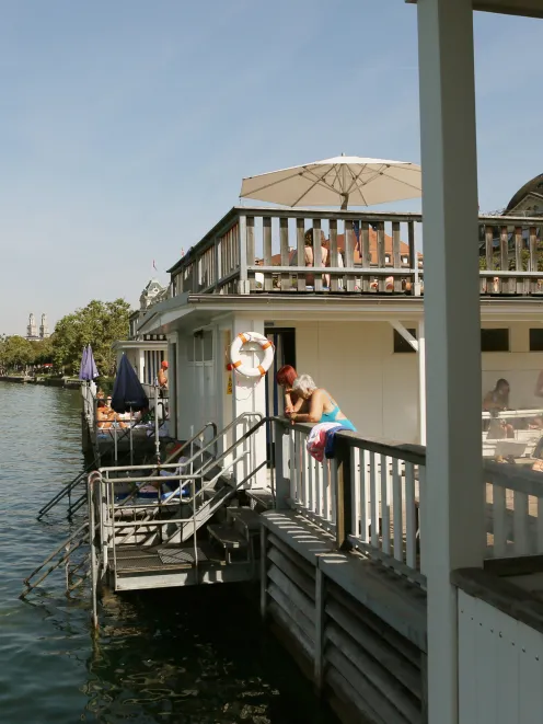 Seeband in der Stadt Zürich mit Menschen die auf die Limmat schauen