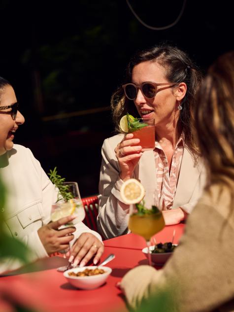 Frau trinke Cocktail auf der Terrasse in der Sonne