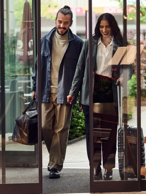 Paar reist im Hotel an und läuft durch die Eingangstüre